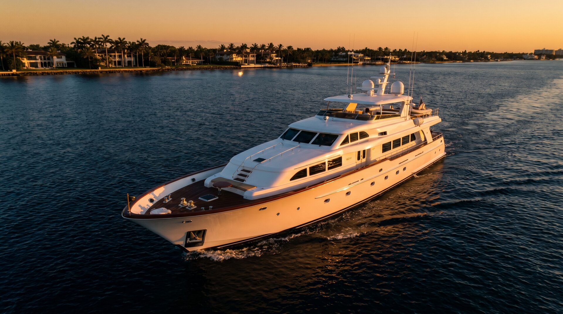 Luxury motor yacht cruising Palm Beach waters at golden hour